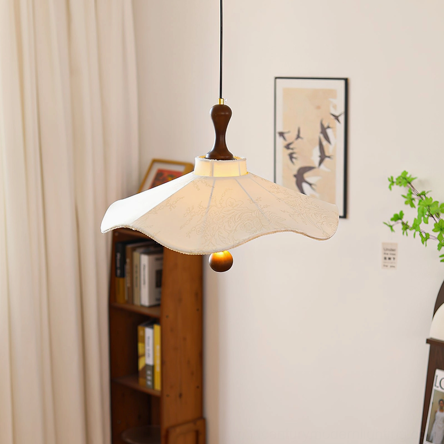 Pendolo ceiling pendant light installed in contemporary study with bookshelf and wall art