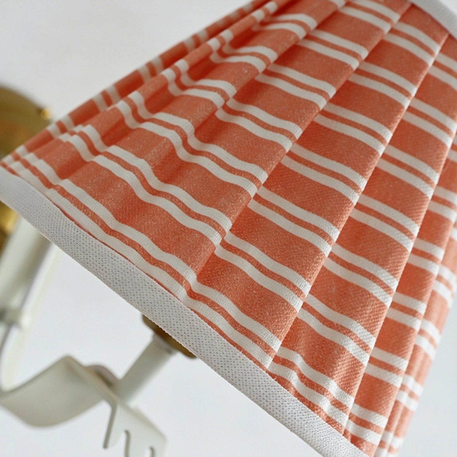 Penelope pleated wall sconce with Edison bulb creating warm interplay of light and shadow through striped fabric