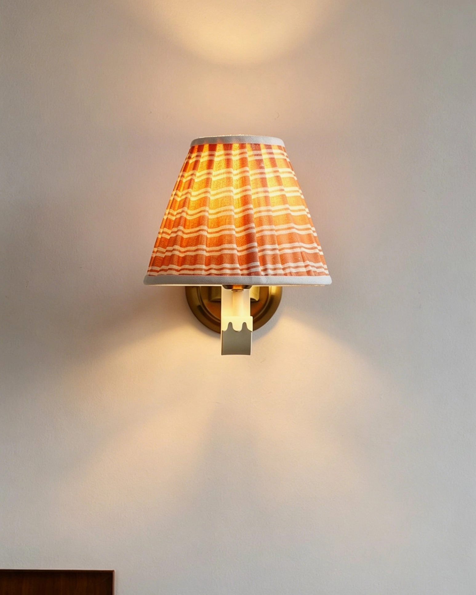 Penelope pleated wall sconce detail view of orange white striped fabric shade and pleating craftsmanship