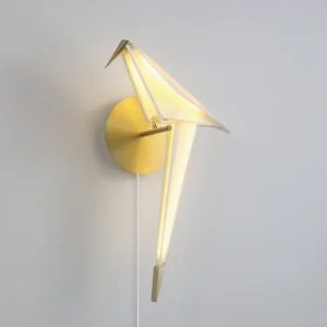 Modern origami bird wall lamp three quarter angle showing sculptural form with white power cord on light gray wall