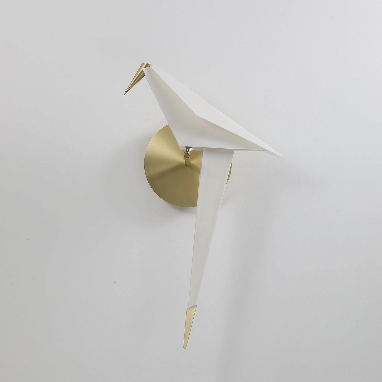 Unlit perching bird wall lamp in white acrylic finish with brushed brass gold base on white background