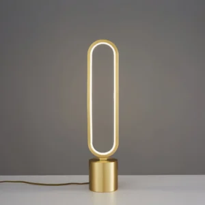 Perigee minimalist table lamp three-quarter view showing gold cylindrical base and integrated LED
