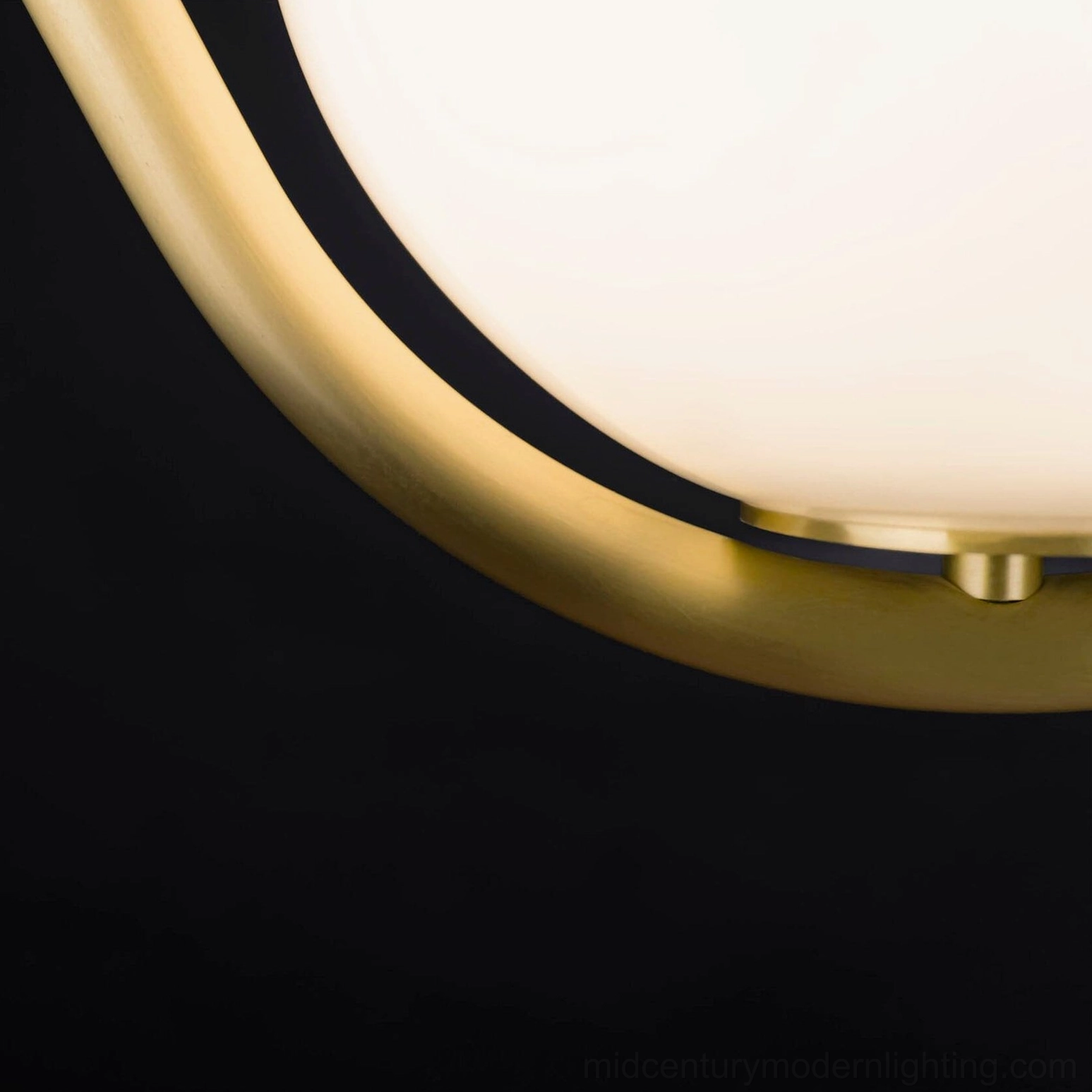 Perle pendant lamp close-up detail showing brass curved frame connection and frosted glass globe craftsmanship