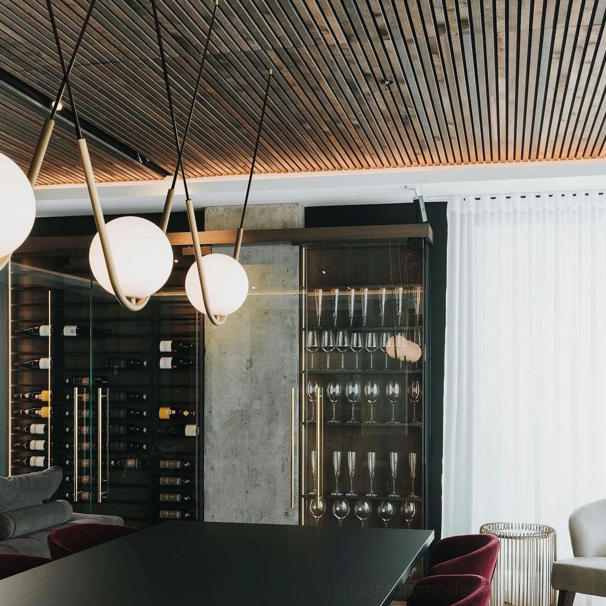 Perle three-head pendant arrangement in sleek modern lounge with wine cabinet and contemporary décor