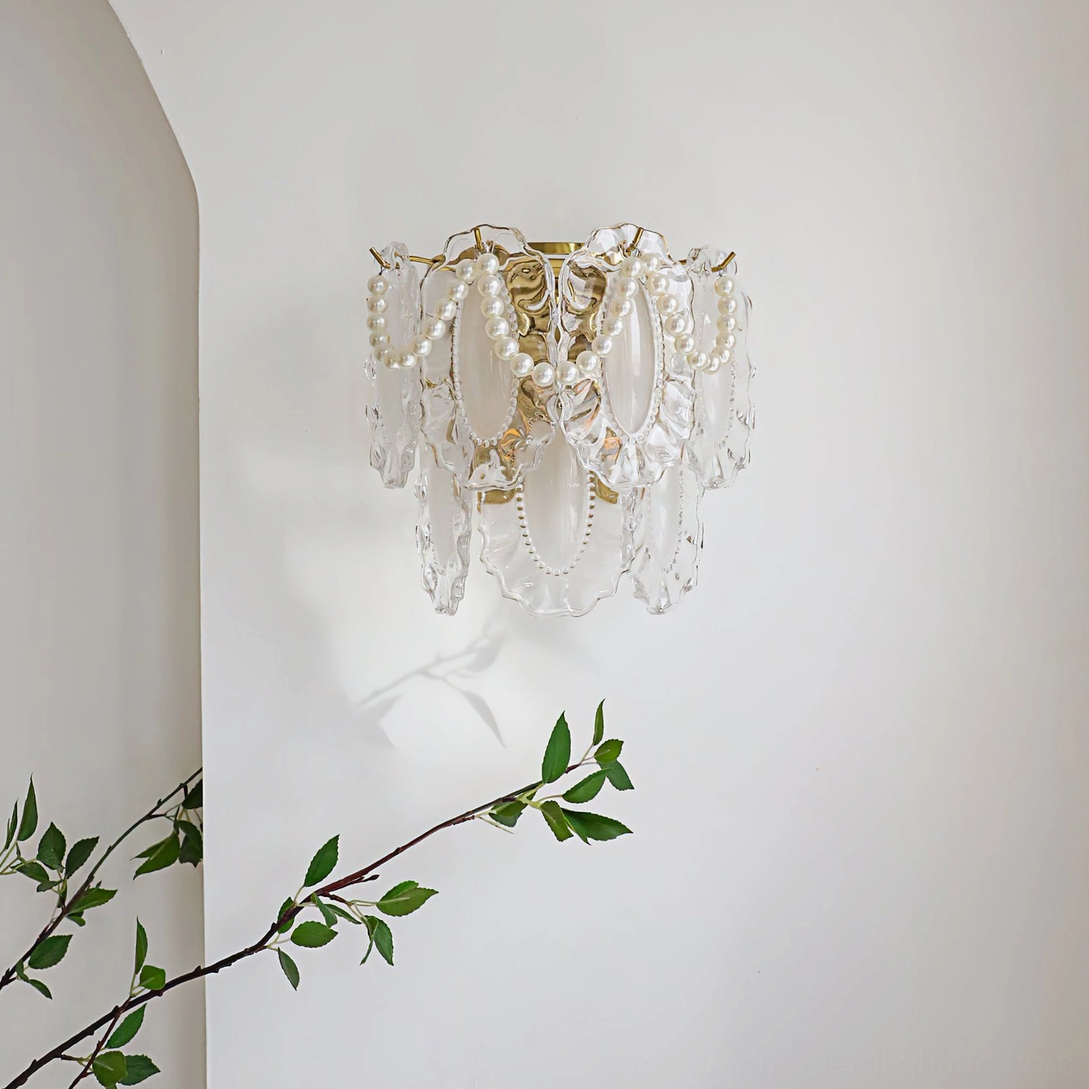 Petal Pearl Wall Light side angle view installed on interior wall with green plant accent