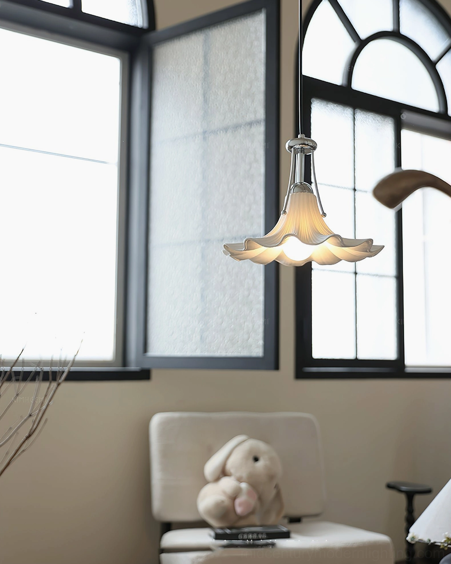 Mid-century modern Petalia pendant light with warm illumination in bright lounge space with windows