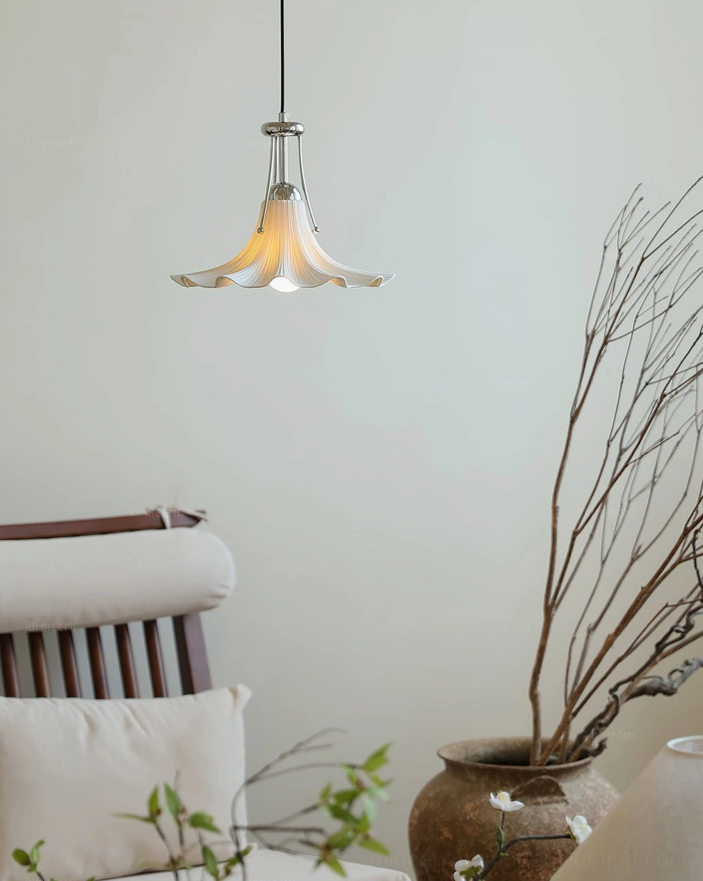 Small Petalia pendant lamp with ruffled ceramic shade in contemporary living space with wooden furniture and dried plants