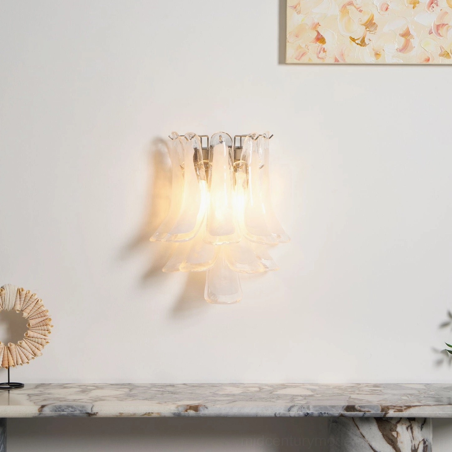 Petral wall sconce with transparent glass petals and brushed metal frame, contemporary design