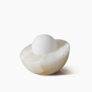 Piccola marble and frosted glass orb table lamp front three-quarter view on white studio background, minimalist modern design
