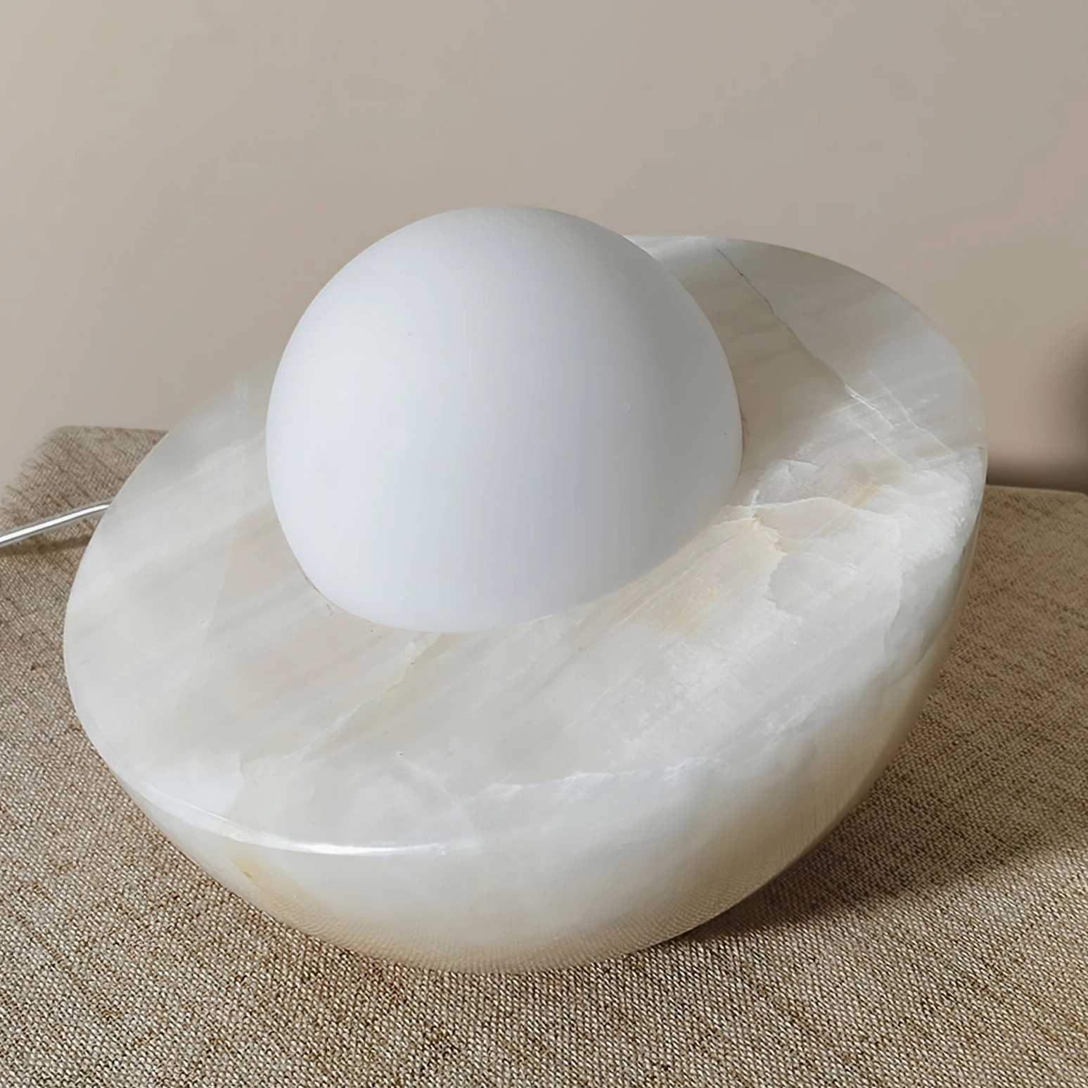 Piccola sculptural marble and glass orb table lamp, wabi-sabi minimalist design, frosted sphere diffuser on carved base