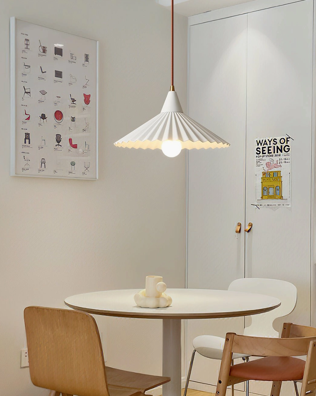 Pieghe pleated pendant light above small round dining table with light wood and white furniture
