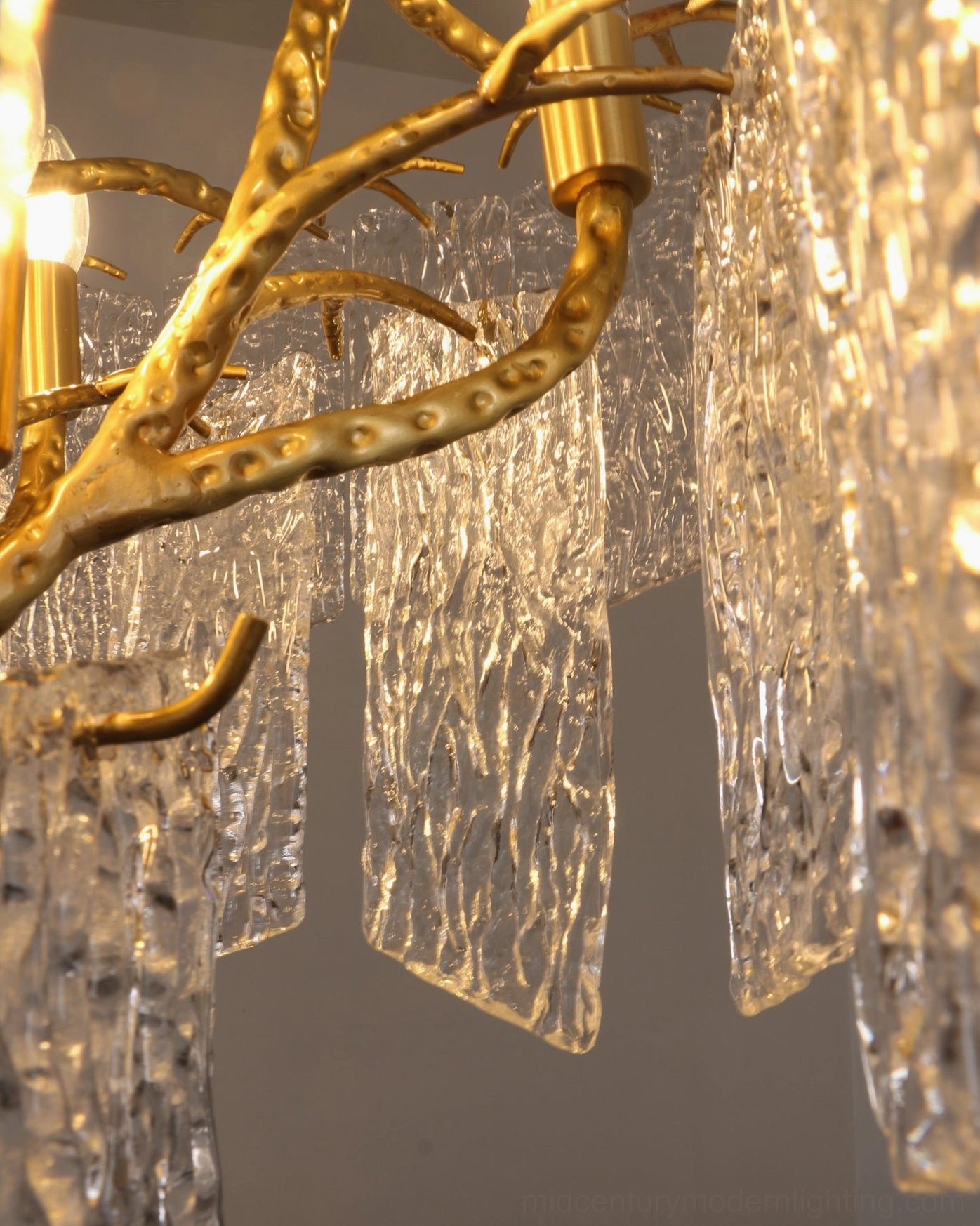 Piemonte brass and glass chandelier hanging in modern home setting with warm ambient atmosphere