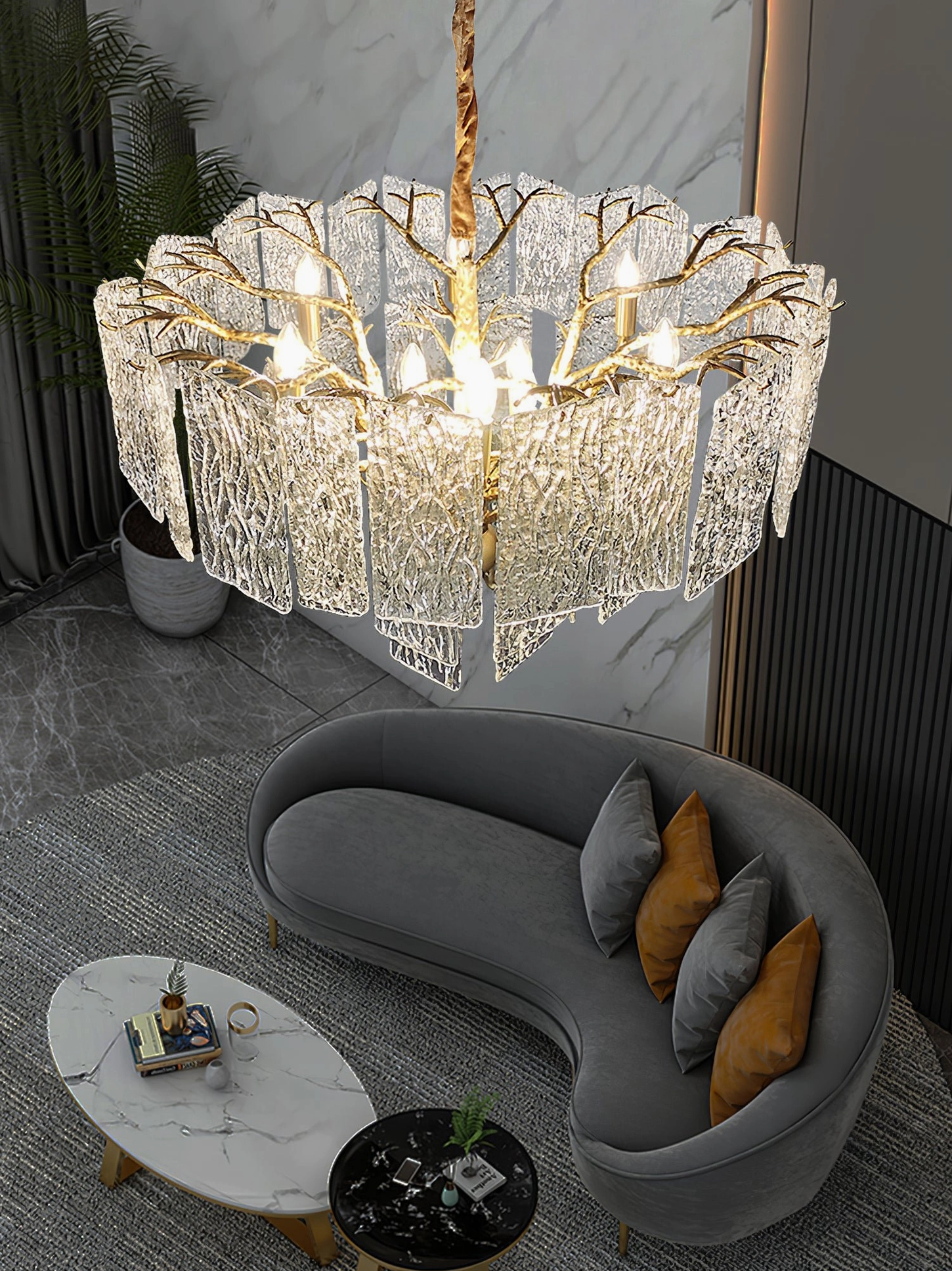 Piemonte textured glass chandelier with branch-shaped gold hardware suspended above curved sofa lounge area