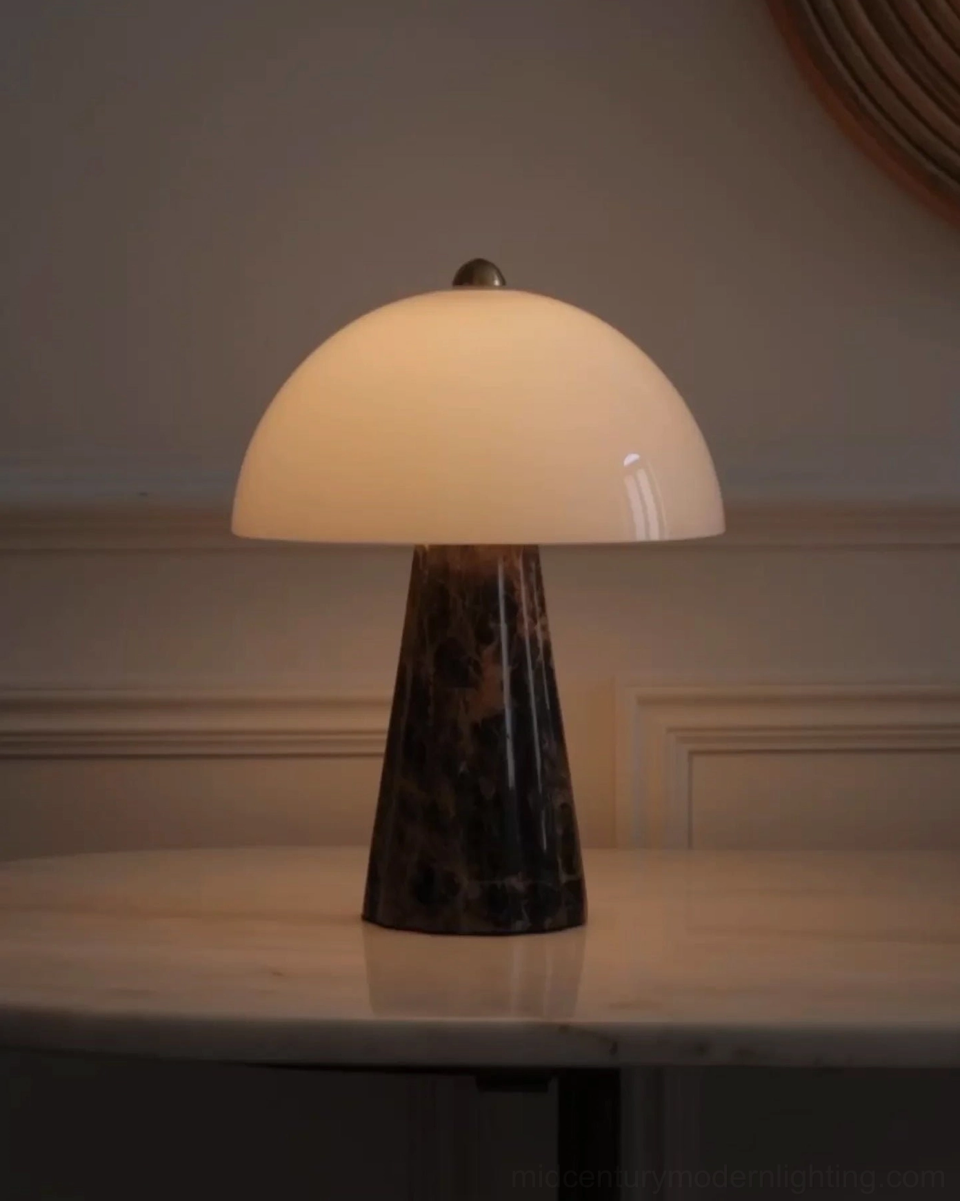 Illuminated Pierre table lamp creating warm ambient glow on cozy side table with dark marble base visible