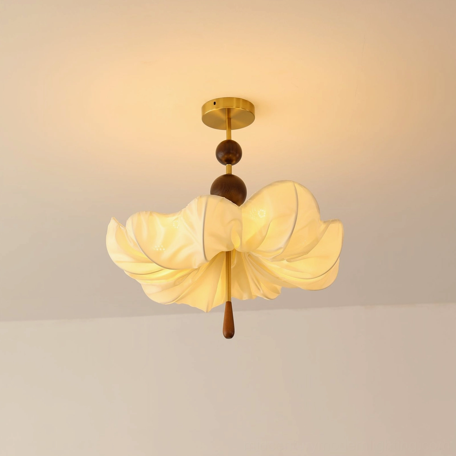 Lit Pinctada ceiling pendant casting warm glow with fabric shade illuminated, vintage brass and wood details