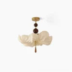 Pinctada fabric ceiling light with sculptural petal-shaped shade, polished brass hardware, and walnut wood accents in studio view