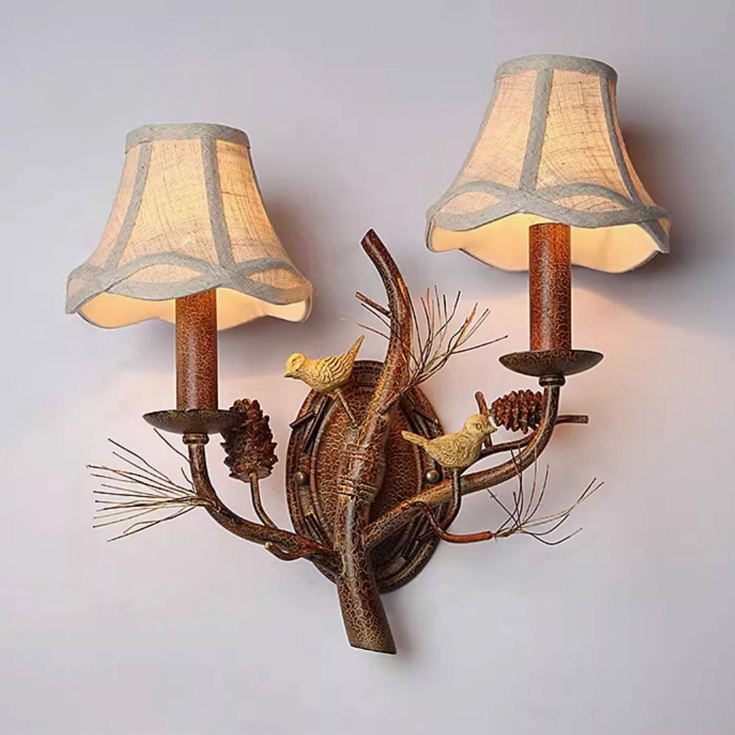 Single-head Pinecone Bird wall lamp with resin bird detail in warm cabin bedroom ambiance