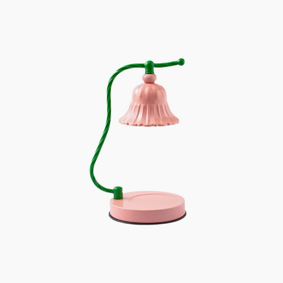 Studio front view of blush pink ceramic fluted table lamp with elegant twisted green metal arm