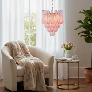 Viola pink glass chandelier hanging in bright living room over seating area with neutral tones and potted plant