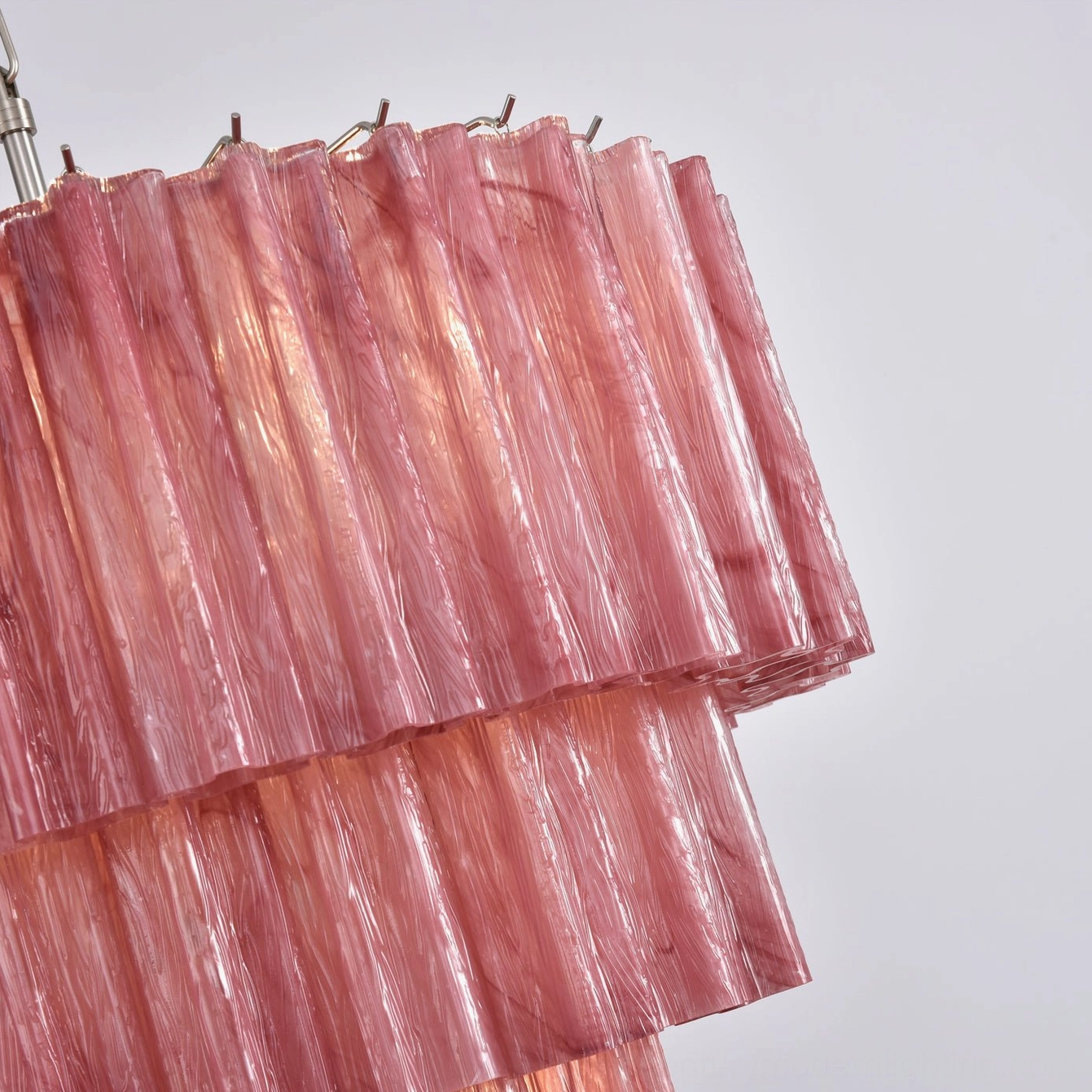 Close-up thick fluted pink glass tubes layered tier structure metal mounting clips detail