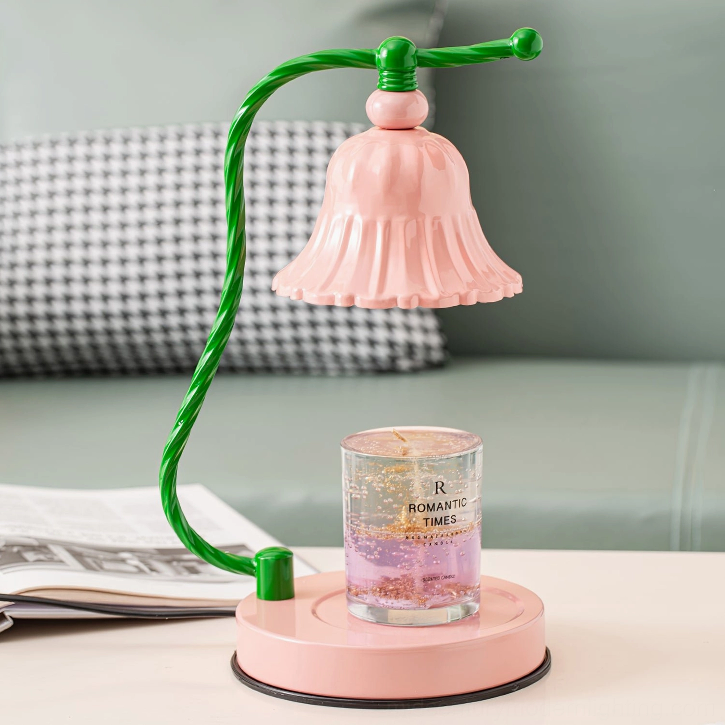 Pink table lamp positioned on side table next to rose dry flowers and decorative books