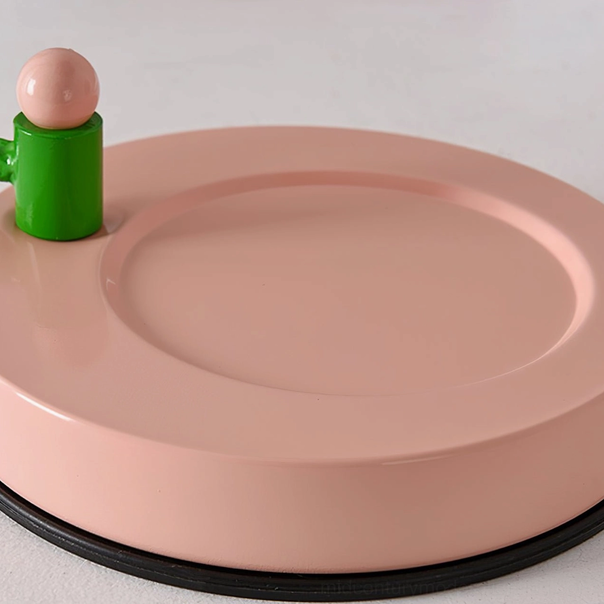 Mid-century modern pink ceramic table lamp creating soft ambient light in cozy interior space