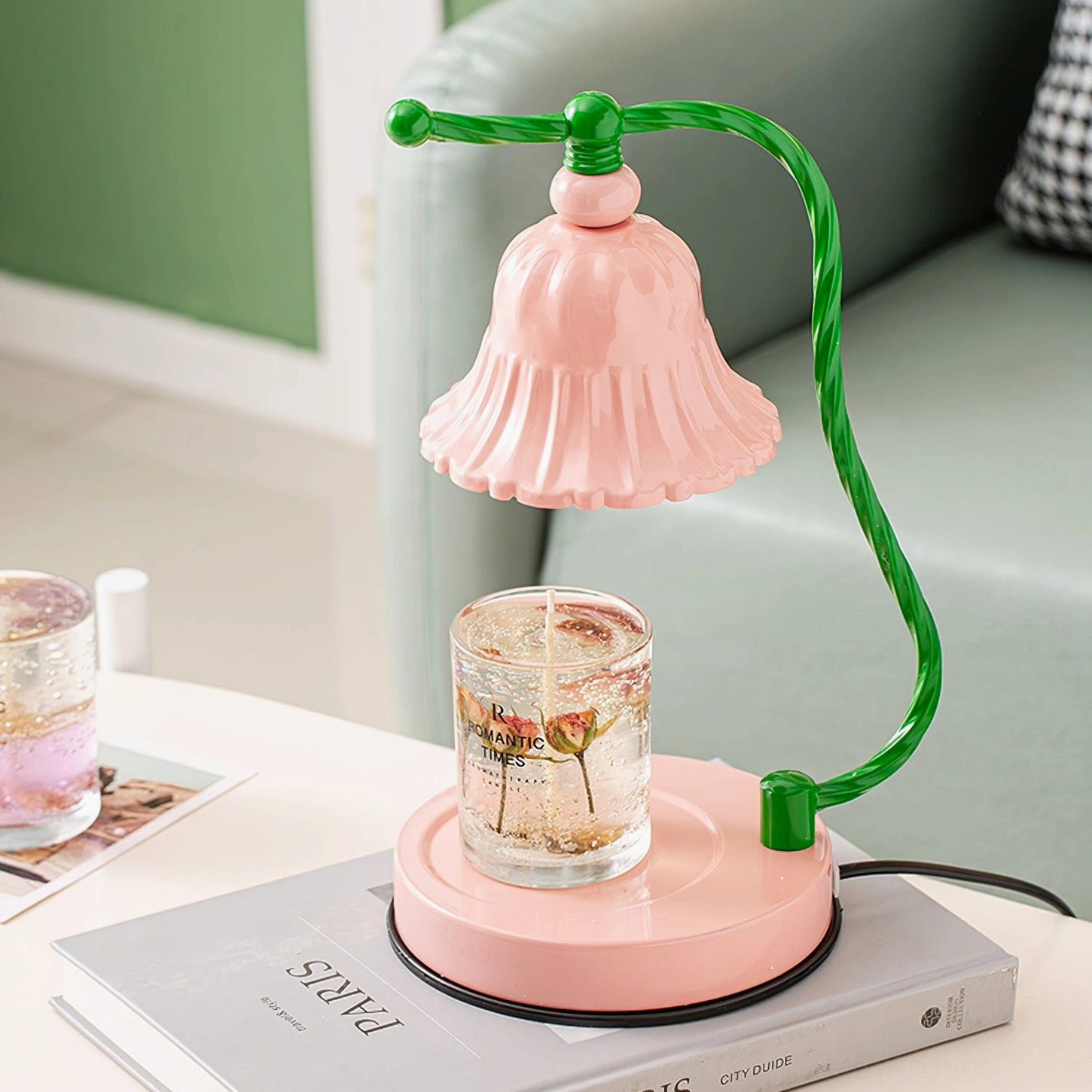 Close-up side view of pink ceramic lamp shade with green twisted metal arm and black non-slip base