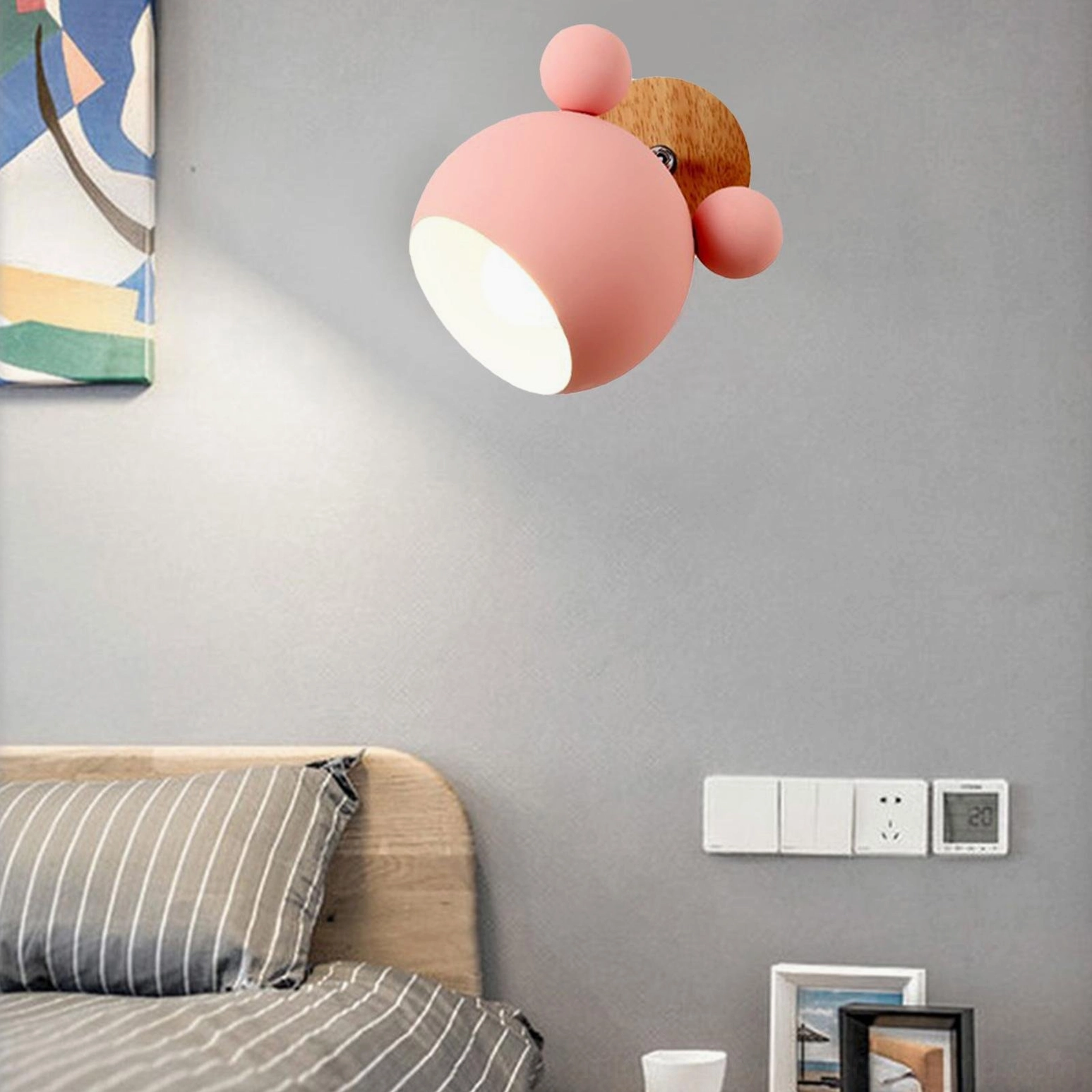 Soft pink mouse sconce mounted on bedroom accent wall with cozy ambiance