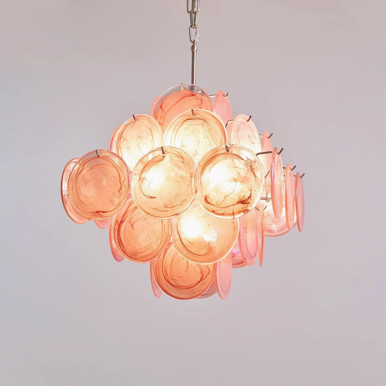 Pink disc Murano glass chandelier installed in minimalist contemporary dining space with architectural lighting appeal
