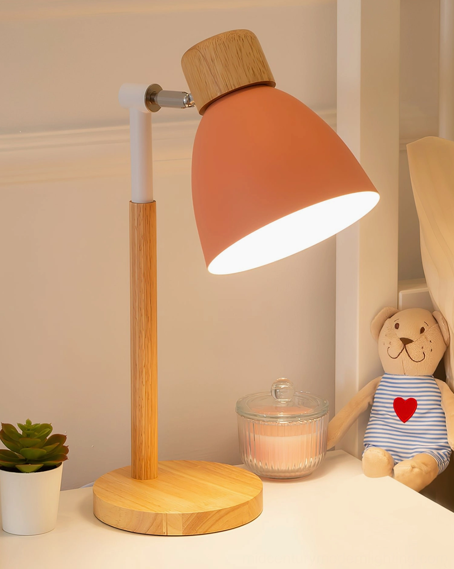 Peach or soft pink shade wood table lamp three-quarter side view with teddy bear and candle, warm minimalist Nordic style
