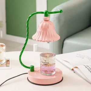 Pink fluted table lamp styled on living room side table with scented candle and books, three-quarter angle