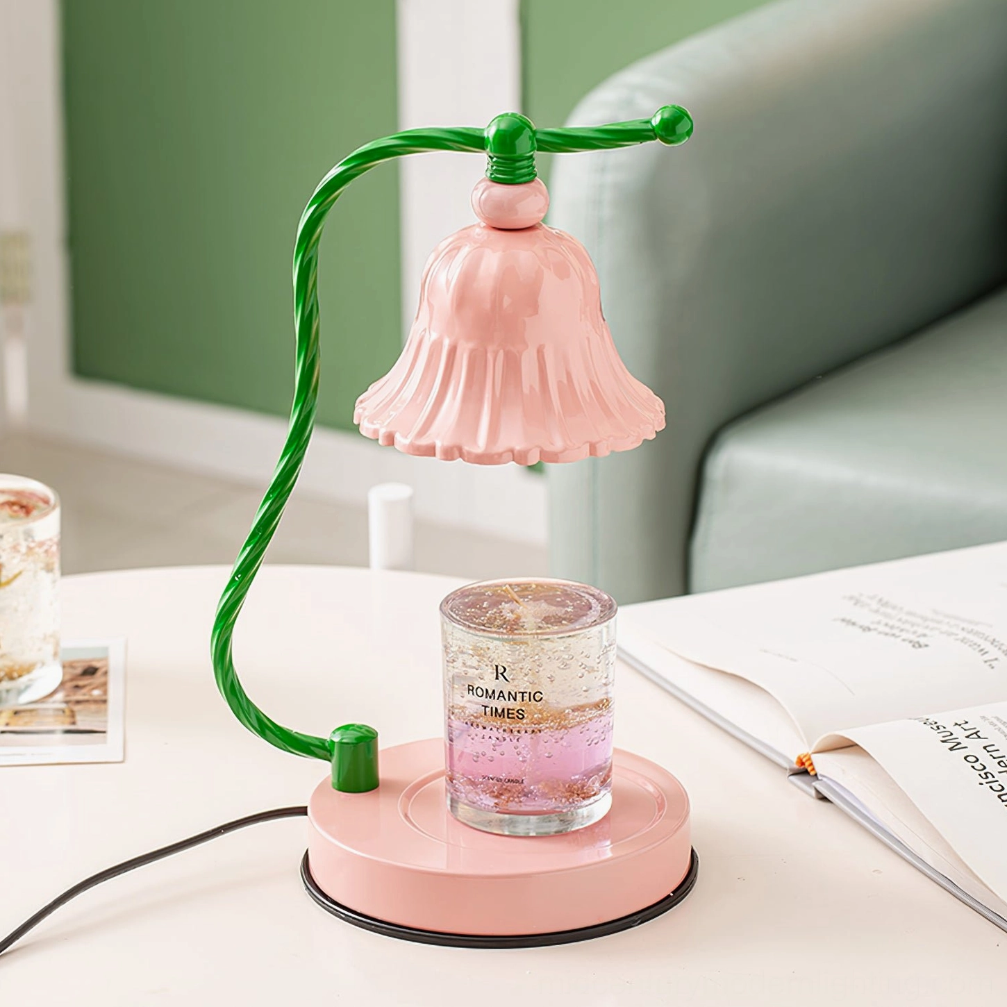 Pink fluted table lamp styled on living room side table with scented candle and books, three-quarter angle