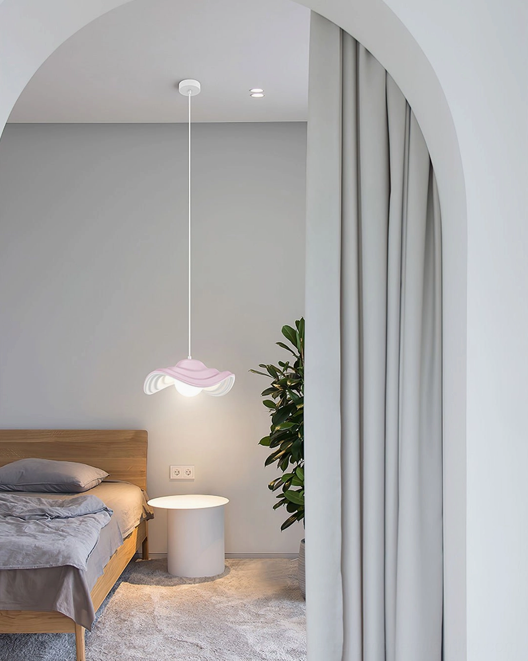 Soft pink wavy pendant light with organic rippled rim design suspended in minimalist bedroom interior with warm ambient lighting