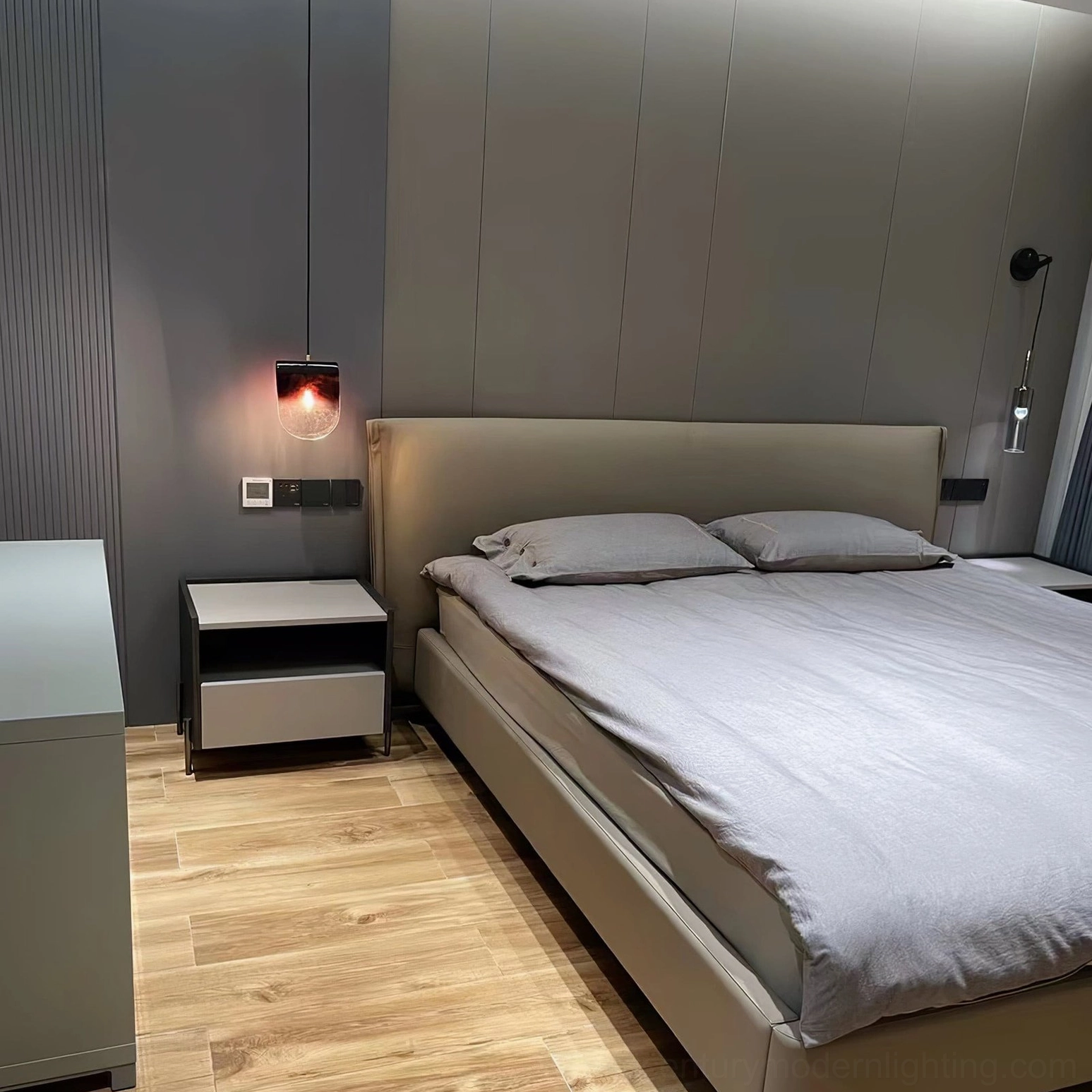 Hand-blown purple gradient pendant light installed above minimalist bedroom bedside in modern home