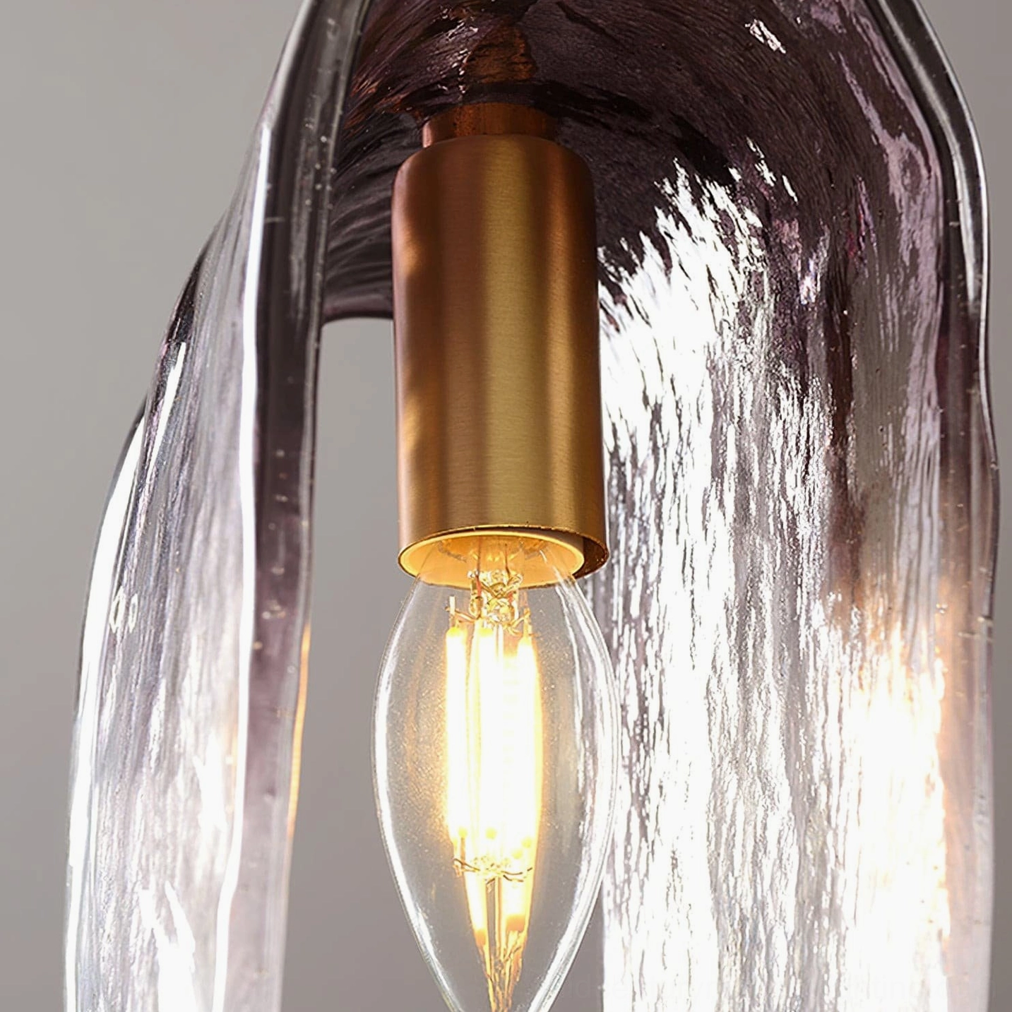 Close-up detail of Planck pendant interior showing brass socket and vintage Edison filament bulb