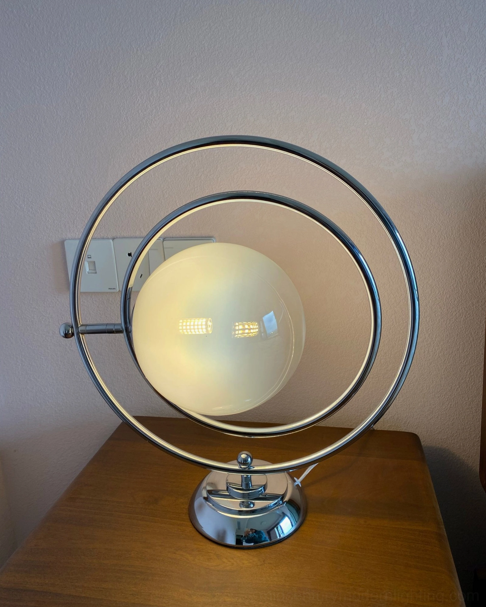 Planet table lamp showing rotating orbital frame adjustment capability