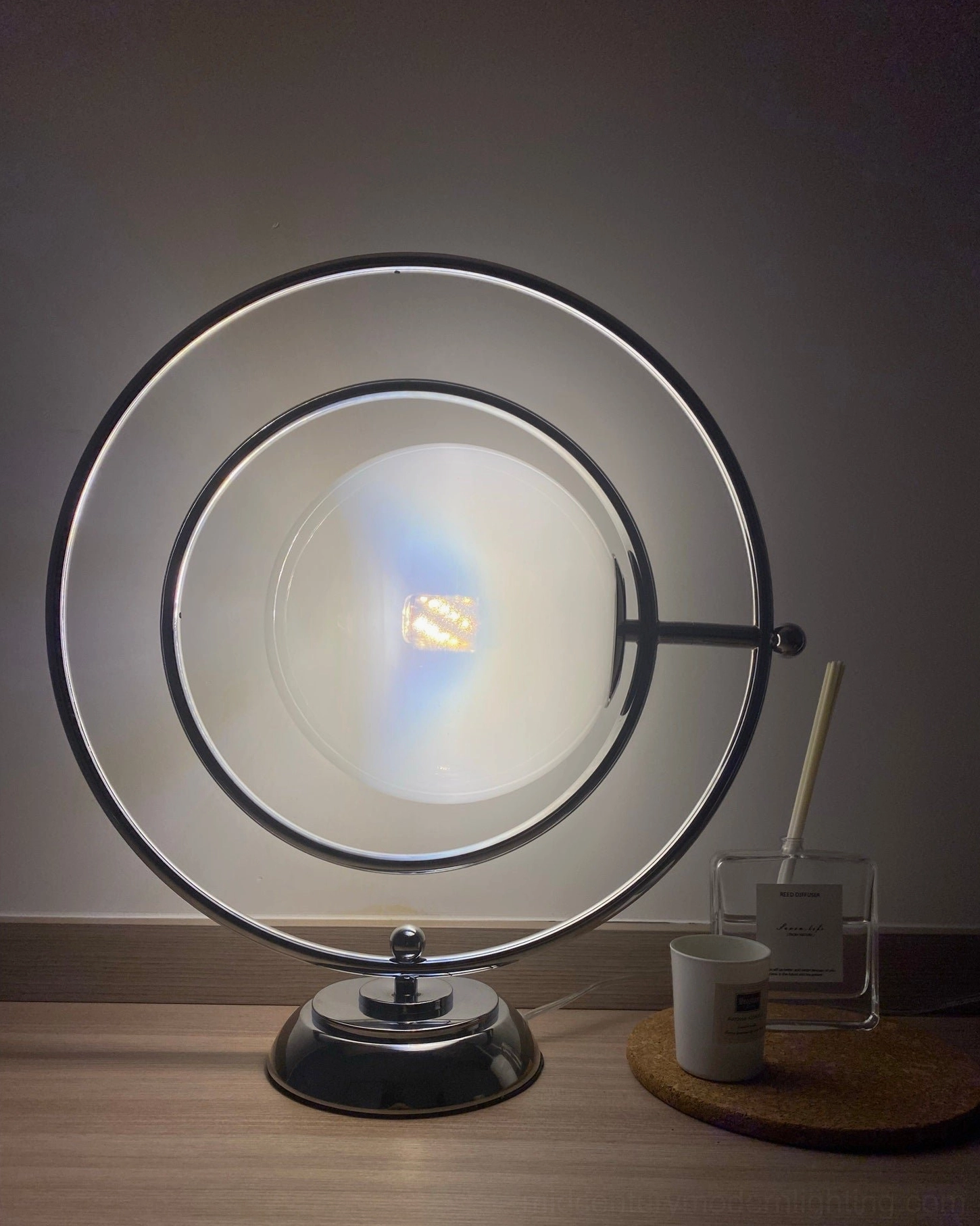 Planet lamp frosted glass shade close-up with polished silver metal ring and dark base