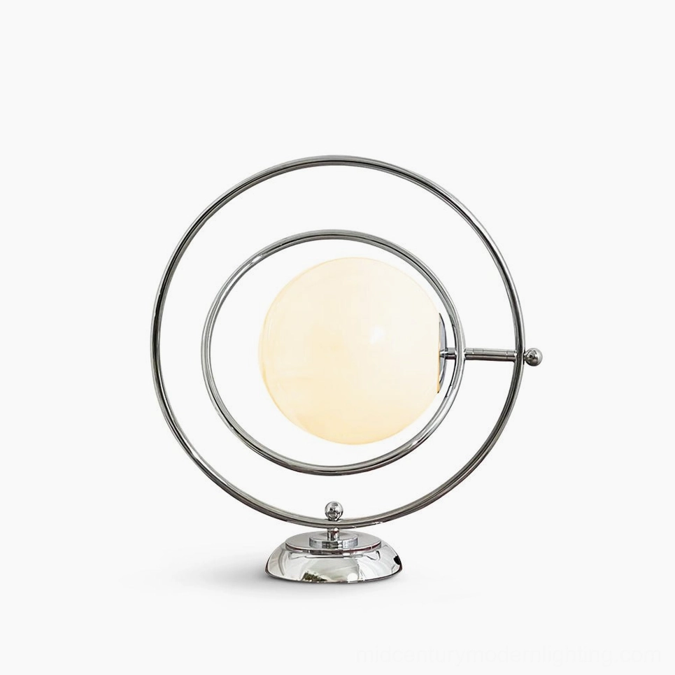 Rotating Planet table lamp with polished silver metal frame and frosted white glass globe on white studio background