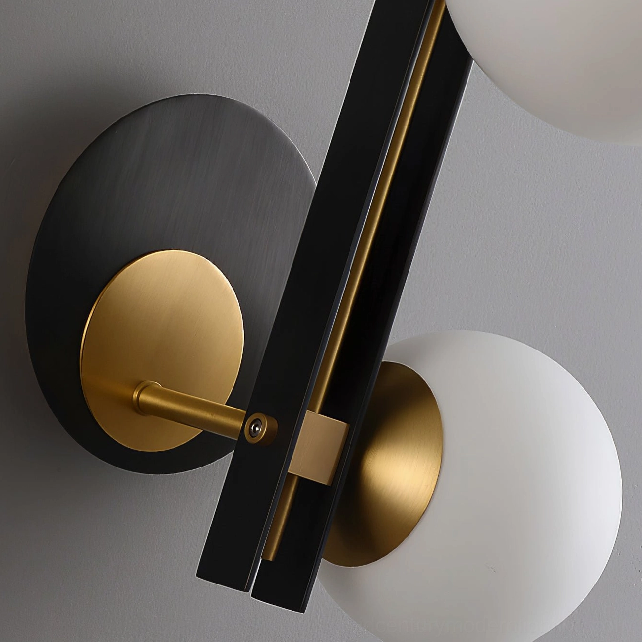 Planeta dual globe sconce detail shot showing exposed brass joints and hardware, frosted glass orbs, minimalist design