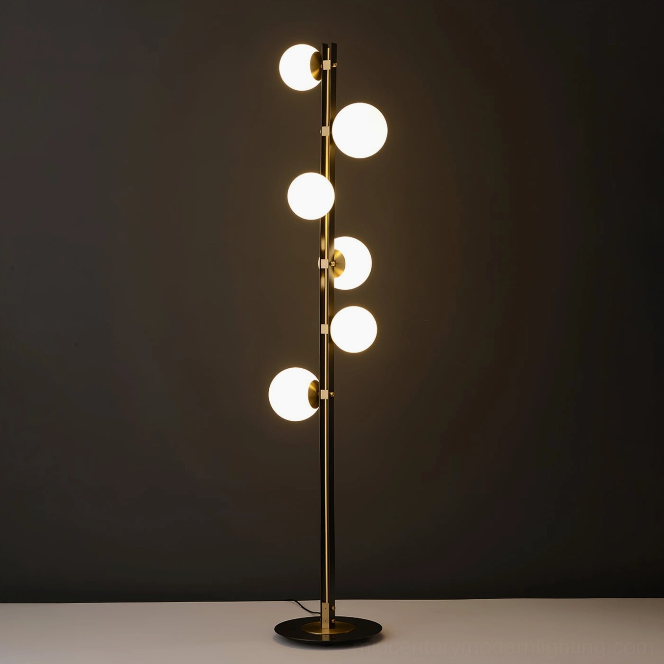 Illuminated Planeta floor lamp showing warm ambient light from white glass globes against dark grey backdrop