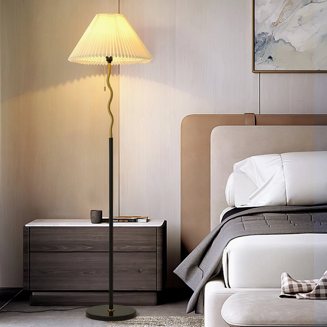 Pleated floor lamp glowing in bedroom with wooden bed and night cabinet, warm ambient lighting