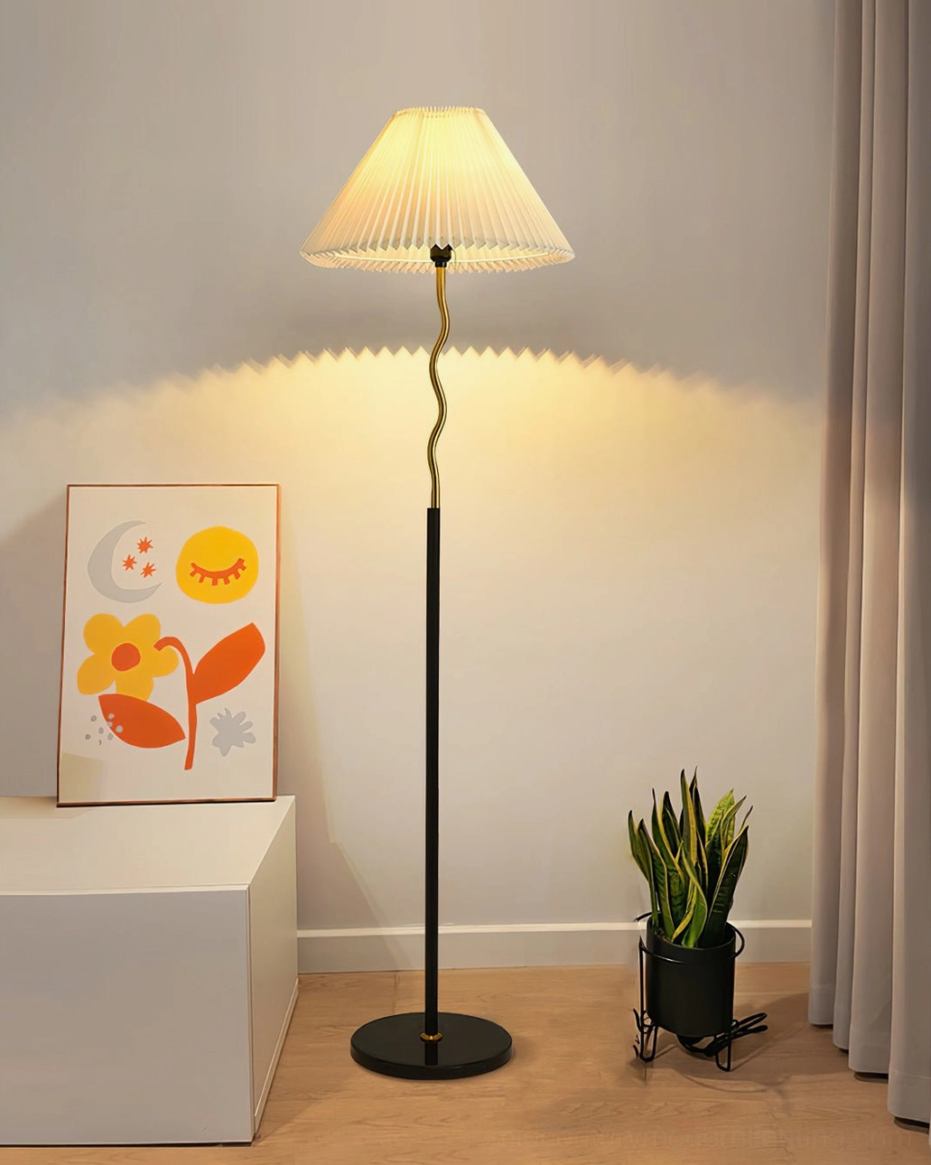 Pleated floor lamp in minimalist corner with wall art and potted plant, emitting warm ambient light