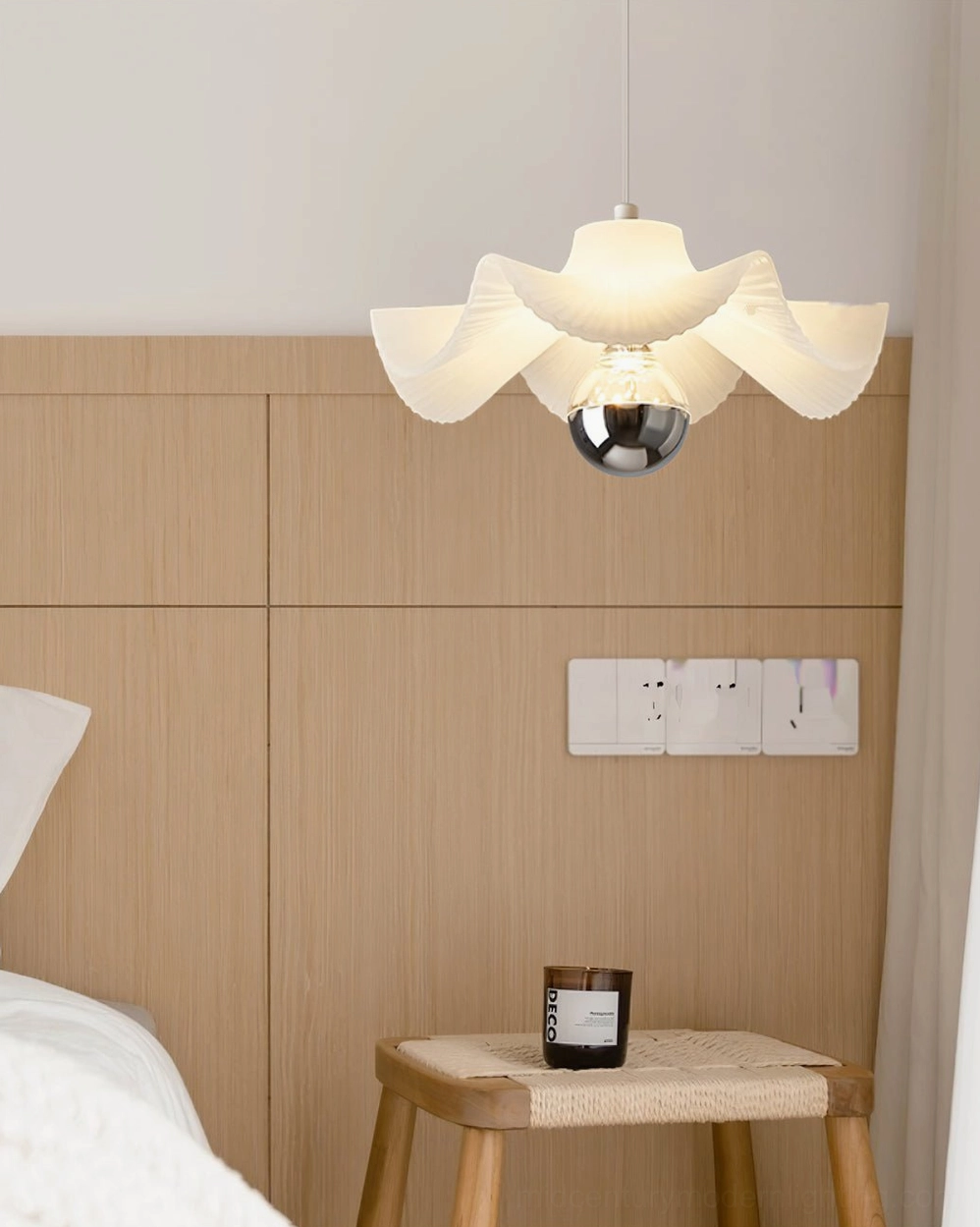 Sculptural pleated pendant light in bedroom with wooden accent wall, contemporary design