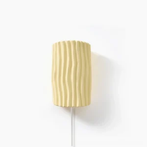 Pleated resin plug-in wall sconce with vertical ribbed texture, frontal studio view on white background