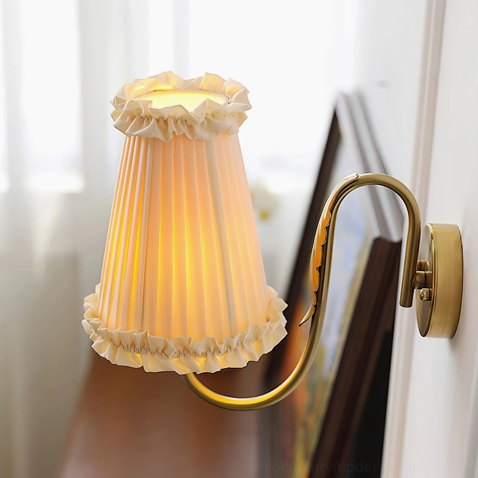 Bottom-front angled view of elegant brass wall lamp with beige pleated shade and ruffled edge detail