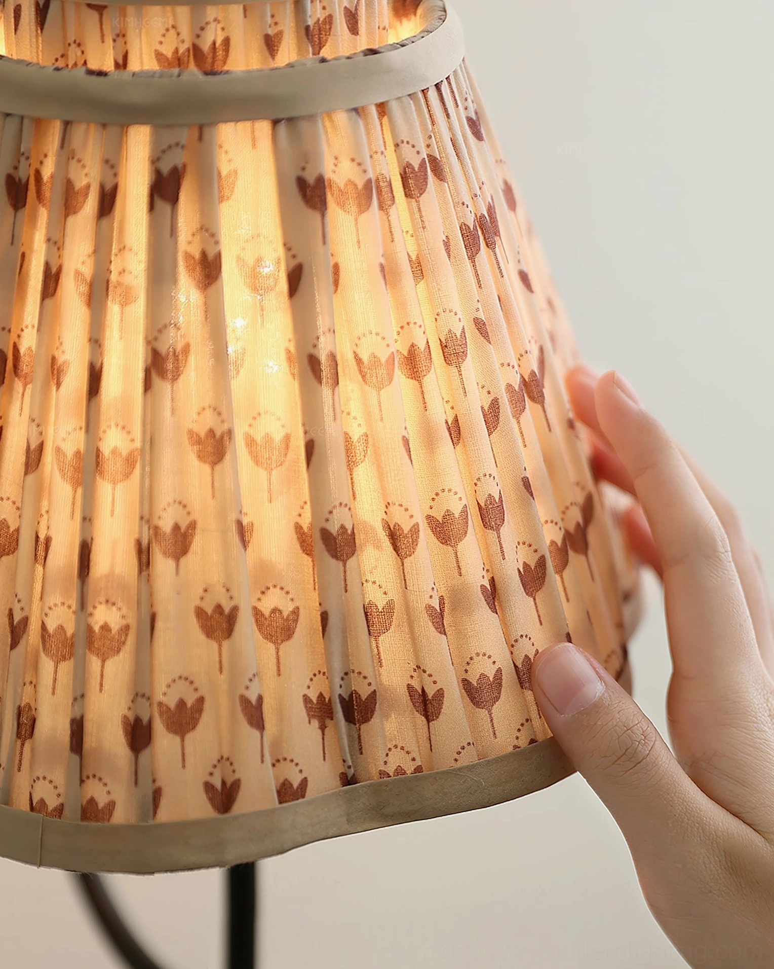 Pleated fabric wall sconce with curved black arm, bedroom accent lighting fixture