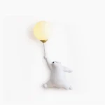 Polar bear balloon wall lamp with frosted glass shade on white studio background - modern whimsical resin sconce