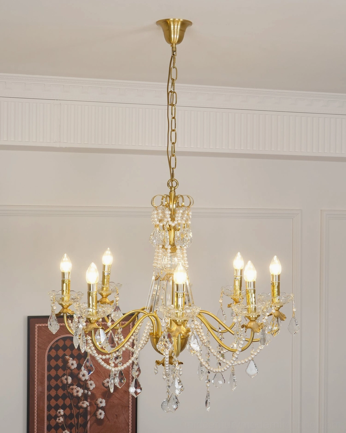 Polished brass chandelier with warm gold tone and cascading clear crystal ornaments in classical setting