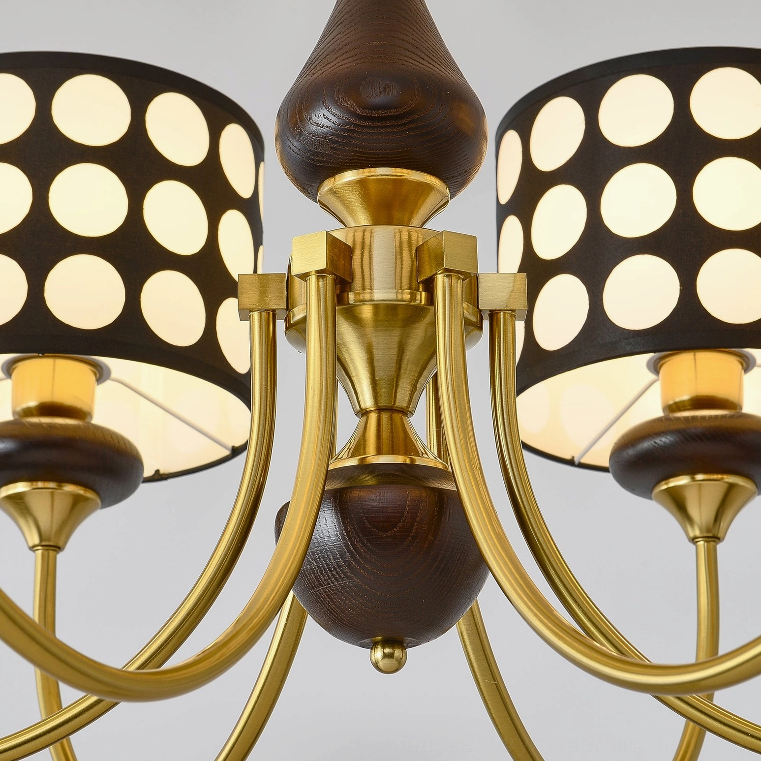 Polka dot chandelier with hollow black fabric shades casting geometric light patterns on walls