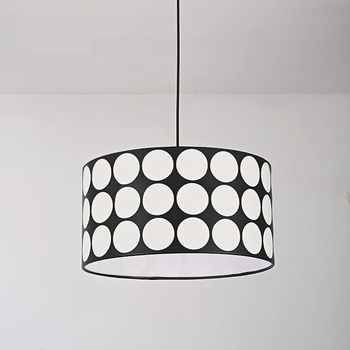 Polka dot pendant lamp viewed from below showing hollow white circle pattern on black metal frame